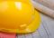 Yellow hard hat on top of wooden planks