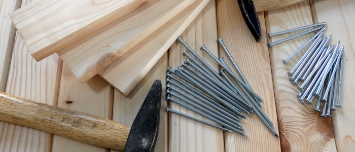 Wooden planks with metal nails and hammers